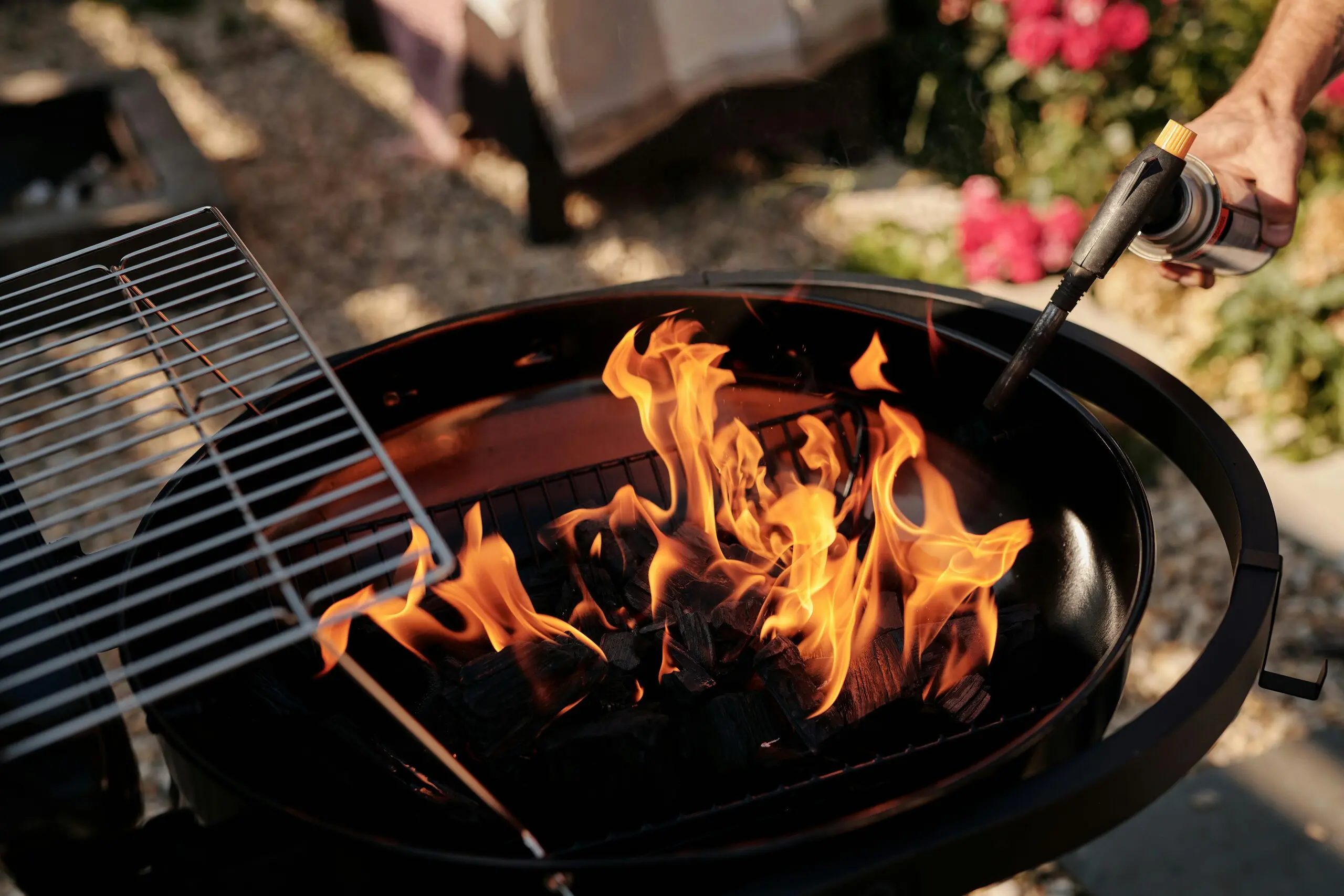 Barbacoa encendida con utensilios y medidas de seguridad